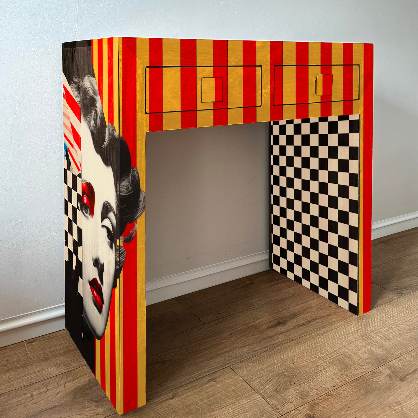 Colourful desk with a face design red and yellow stripes and checkered pattern on a wooden floor.